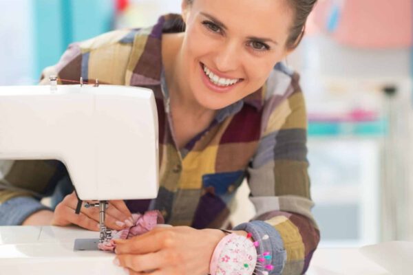 Happy seamstress sewing in studio